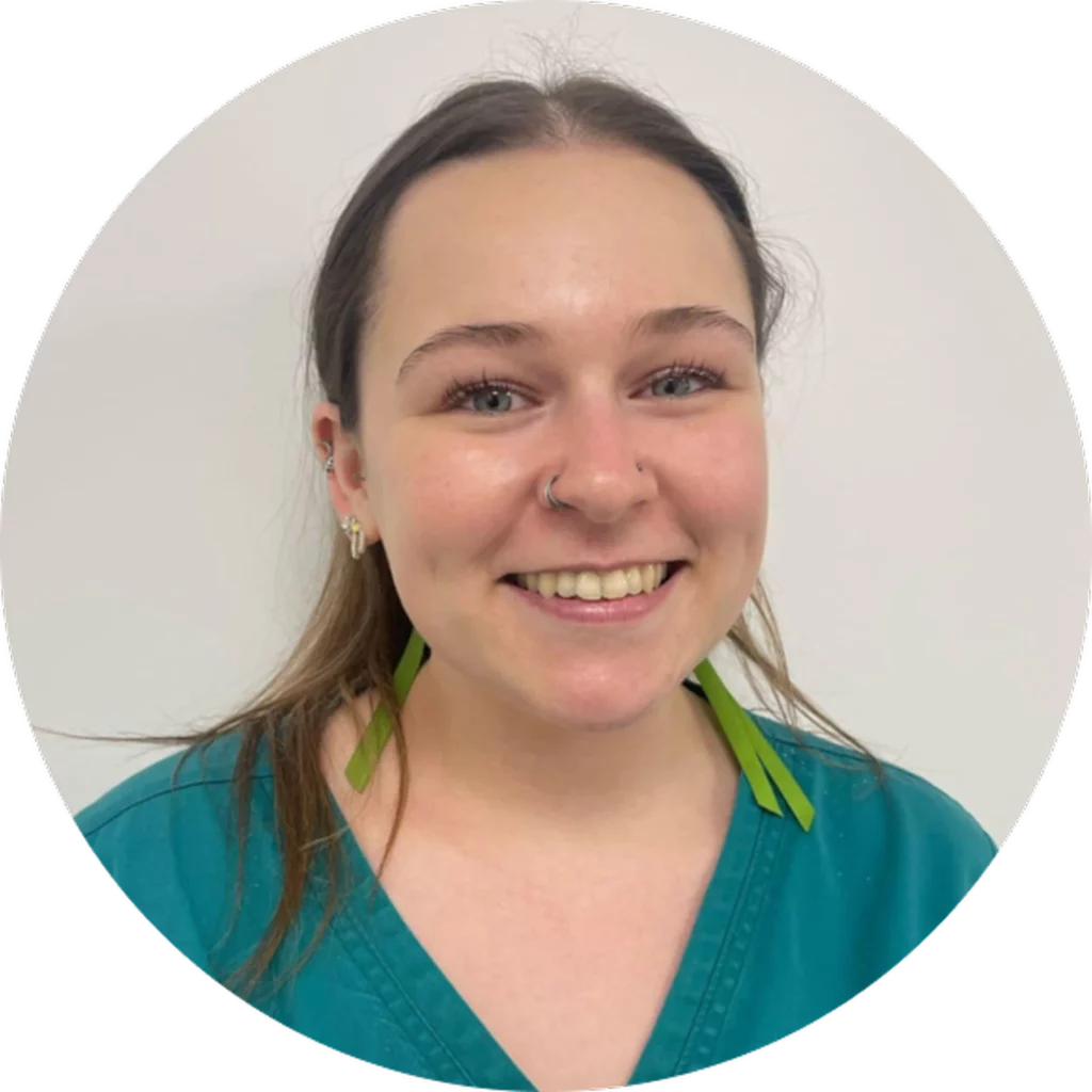 Smiling person wearing teal scrubs