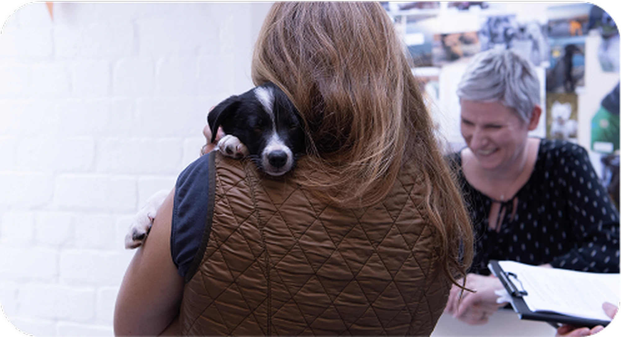 A person with long hair, wearing a brown quilted vest